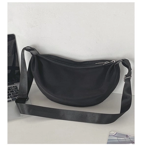 Detail of minimalist black crescent bag with wide adjustable strap and metal zipper
