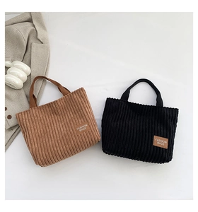 Close-up of corduroy tote bags in brown and black with leather fashion patches