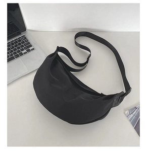 Minimalist black crescent crossbody bag with adjustable wide shoulder strap and top zipper