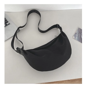 Top view of a black crescent nylon shoulder bag with adjustable strap and zip closure