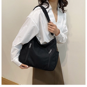 Détail du sac fourre-tout noir avec poches zippées et matière en nylon durable et imperméable