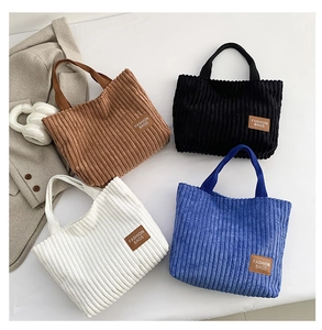 Close-up of corduroy tote bags in four colors with stylish leather fashion labels