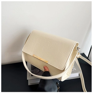 Close-up of cream rectangular flap bag featuring gold metal hardware and wrinkled texture