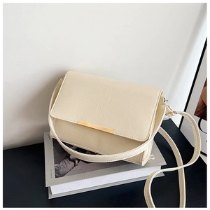 Detail of cream crossbody bag with crinkled faux leather texture and gold metal bar buckle