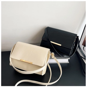 Detail of minimalist leather crossbody bags with sleek gold metal bar decoration