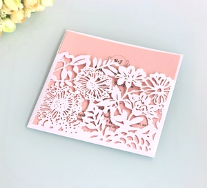 Detail van lasergesneden bloemenhoes met roze uitnodigingskaart voor de bruiloft