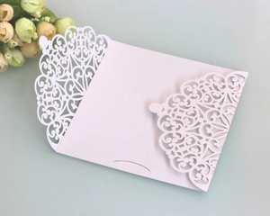 Elegant white laser-cut European style invitation card with floral patterns on blue surface