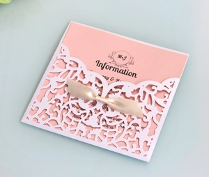 Détail de l'invitation de mariage découpée au laser avec carte rose et ruban de soie champagne