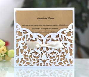 Détail de l'invitation de mariage découpée au laser avec motifs floraux et nœud en soie