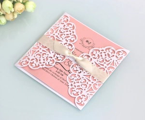 Elegant white laser-cut wedding invitation with pink card and beige satin ribbon bow