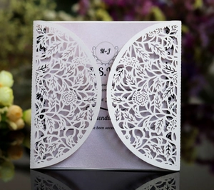 Nordic white laser-cut wedding invitation featuring intricate floral and leaf patterns