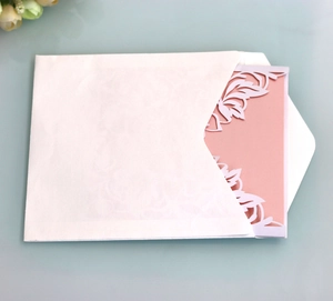 Macro detail of laser-cut floral pattern on pearlescent paper wedding invitation