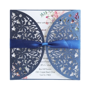 Laser cut blue pearl paper wedding invitation with pink floral insert and navy ribbon