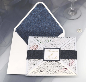 Dettaglio dell'invito di nozze intagliato al laser con fodera glitter blu navy e tag