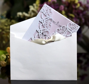 Elegant laser cut LOVE wedding invitation card with pink insert and cream ribbon bow