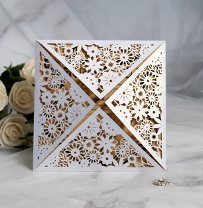 Detail of laser-cut floral wedding invitation with gold pearlescent inner card
