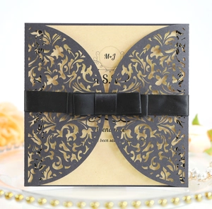 Vue macro du motif découpé au laser et du ruban en satin noir sur l'invitation de mariage