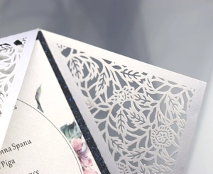 Dettaglio dell'invito tagliato al laser con custodia bianco perlato e carta glitter blu