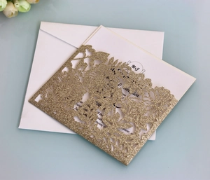 Detail van het lasergesneden bloemmotief met gouden glitters op de huwelijksuitnodiging