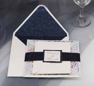 Eleganti inviti di nozze tagliati a laser con inserto blu navy glitterato e fascia decorativa
