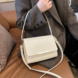 Minimalist white textured leather crossbody bag with elegant gold metal buckle detail