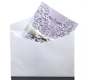 Elegant white lace laser-cut invitation card with lavender insert and beige ribbon bow