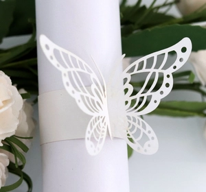 Macro shot of white laser-cut butterfly paper napkin ring with pearl finish detail