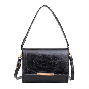 Minimalist black oil wax leather crossbody bag with elegant gold metal trim detail