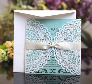 Elegant laser cut white lace wedding invitation set with light blue card and satin bow