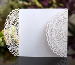 Detail of laser-cut lace mandala pattern on elegant white pearlescent wedding invitation