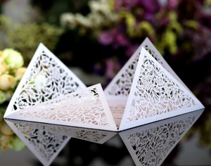 Dettaglio macro di un elegante biglietto d'invito a nozze bianco intagliato al laser