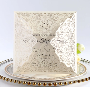 Detail of laser-cut lace floral pattern on off-white wedding invitation card