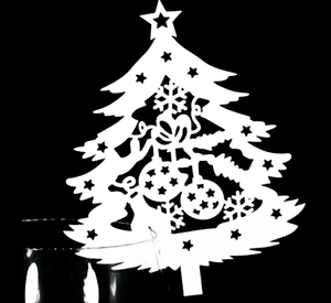Detail view of laser-cut white Christmas tree place cards for holiday table setting