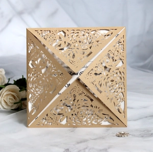 Detail of laser-cut rose floral wedding invitation with sparkling gold texture and rhinestone