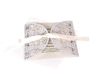 Elegant laser cut floral wedding invitation suite with cream ribbon and white envelopes
