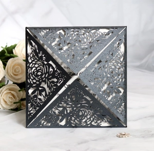 Macro detail of laser-cut rose patterns on elegant black glitter wedding invitations