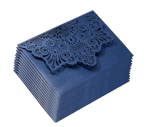 Macro detail of laser cut navy blue invitations with intricate mandala patterns