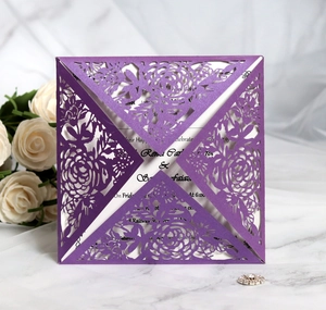 Elegant purple laser cut floral wedding invitation on white marble with roses