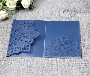 Detail of navy blue laser-cut wedding invitation with intricate mandala floral patterns