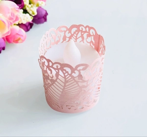 Detail of pink laser-cut paper candle holder with floral leaf patterns and LED tealight