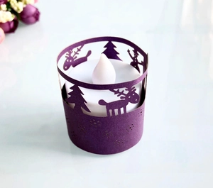 Close-up of purple laser-cut Christmas paper lampshade with deer and tree patterns