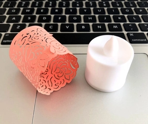 Laser cut hollow paper tea light wraps with LED electronic candles for party decor