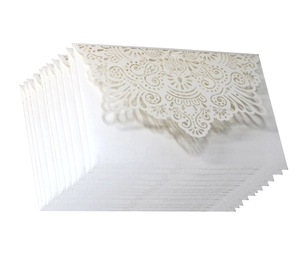 Detail showing intricate laser-cut lace floral patterns on white wedding invitation envelopes