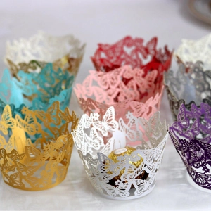 Laser cut butterfly cupcake wrappers in various pearlescent colors for wedding decor