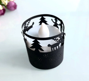 Close-up of LED tea light with reindeer and Christmas tree silhouette paper lampshade