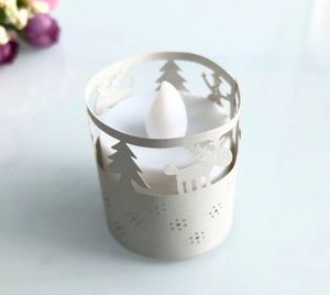 Close-up of LED tea light with reindeer and snowflake cutout festive paper lampshade