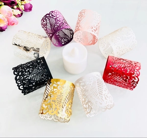 Various laser cut paper tea light wraps with intricate leaf patterns in multiple colors