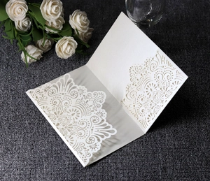 Detailed laser-cut mandala lace pattern on elegant white pearlescent wedding invitation