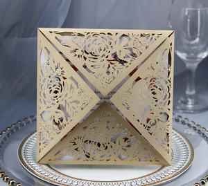 Detail of laser-cut floral wedding invitation in champagne gold pearlescent paper