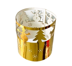 Macro view of golden hollow Christmas deer and tree patterns on a cylinder tea light cover